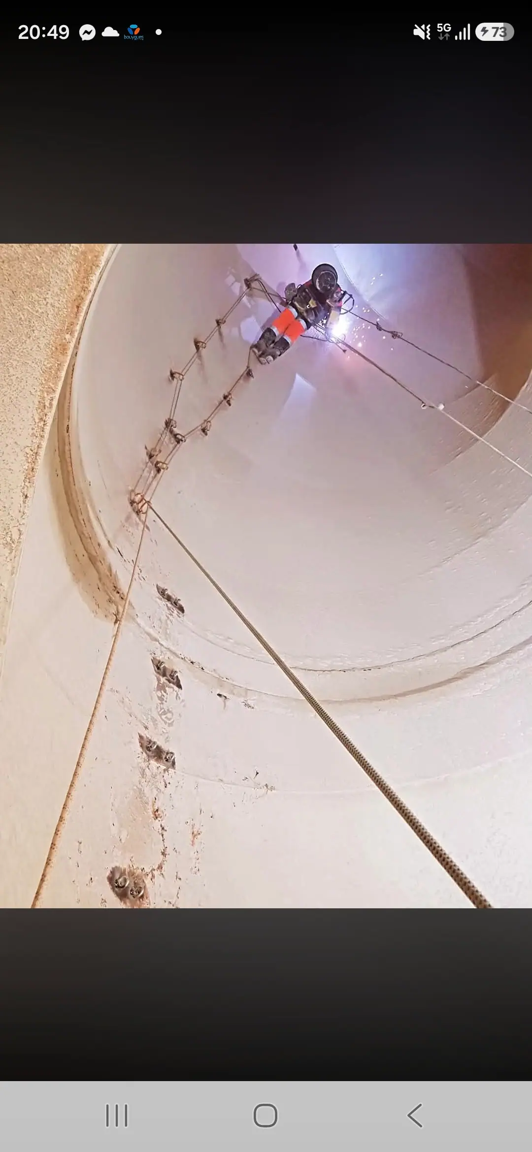 Cordiste réalisant une opération de soudure à l’intérieur d’un ouvrage