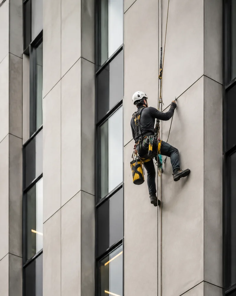 Technicien cordiste intervenant sur une façade